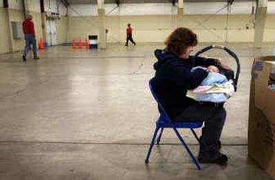 
As Christmas Bureau workers cleaned up Friday afternoon, Glo Mitchell and her infant son, Kaden, complete paperwork to receive gifts. 
 (Brian Plonka / The Spokesman-Review)