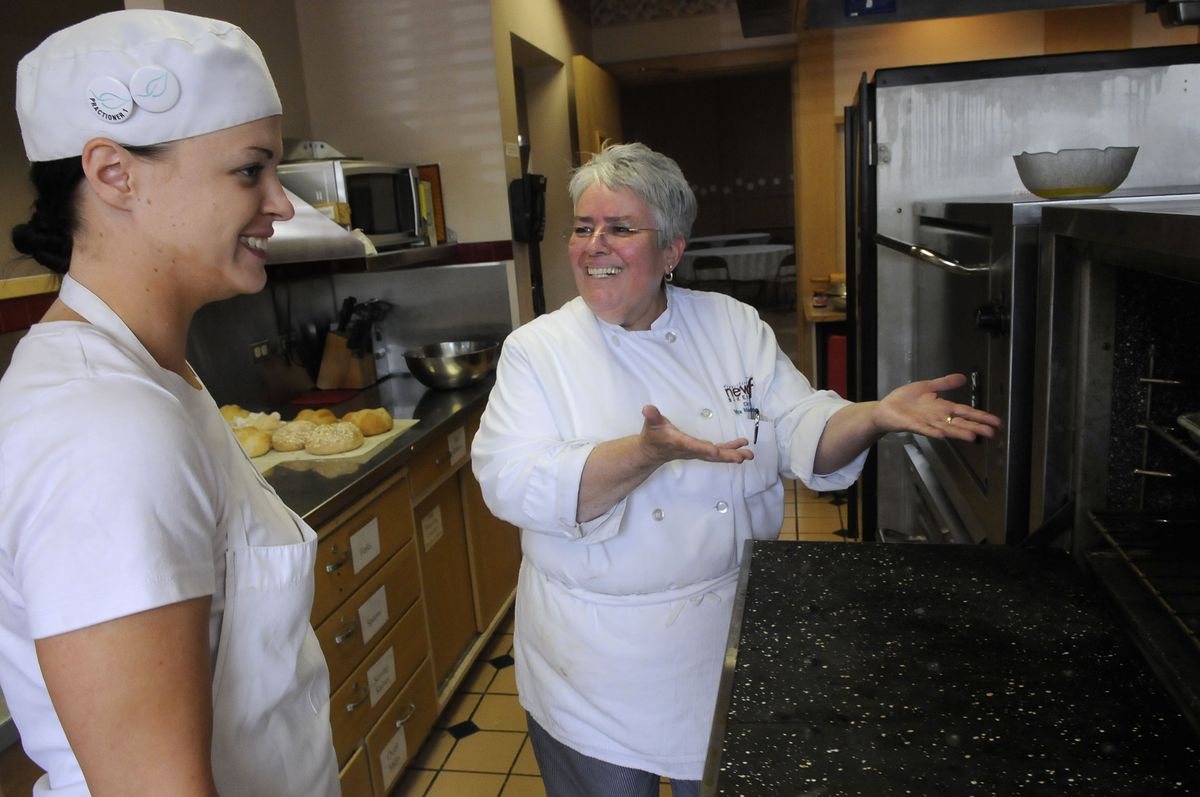 Vira Melendez-Redman, right, heaps high praise upon her student Shannon Sharp after viewing Sharp’s fresh baked cinnamon rolls at the Transitions New Leaf Bakery in Spokane’s St. John’s Cathedral on May 13.  (Photos by Dan Pelle / The Spokesman-Review)
