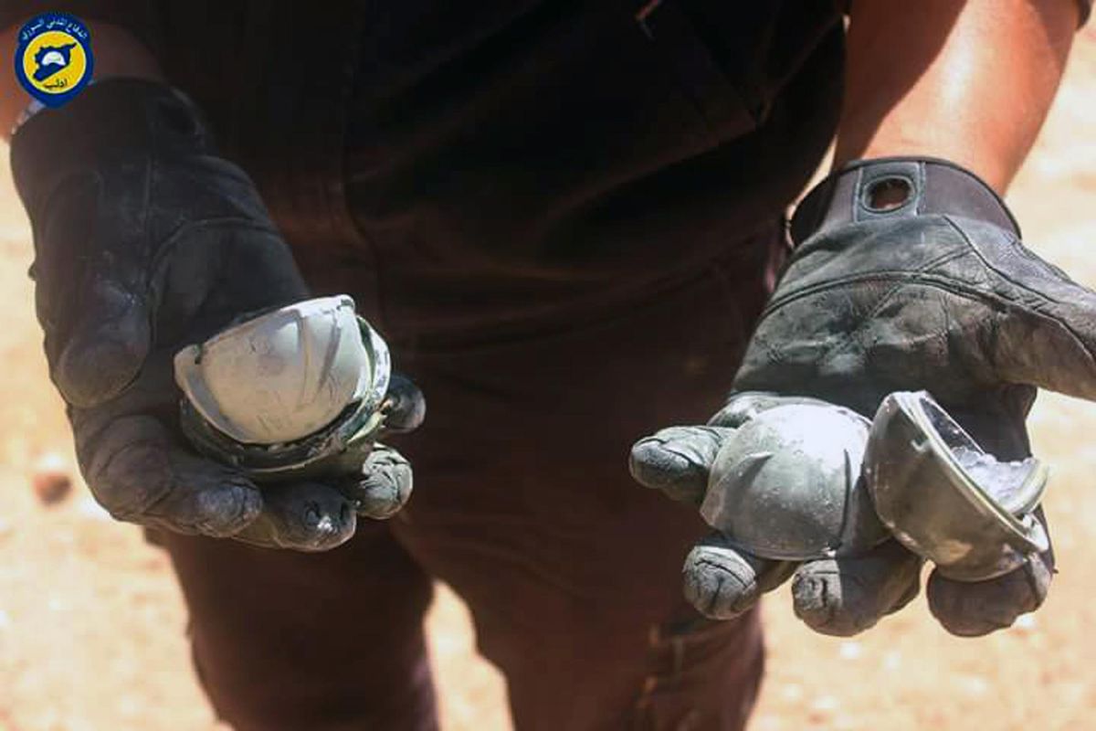 In this photo provided by the Syrian Civil Defense group known as the White Helmets, shows a member of Civil Defense displays the cluster bombs in the Khan Sheikhoun neighborhood of Idlib, Syria, Thursday, Sept. 29, 2016. The U.S. and Russia escalated their war of words over Syria Thursday as government forces kept up their assault on Aleppo