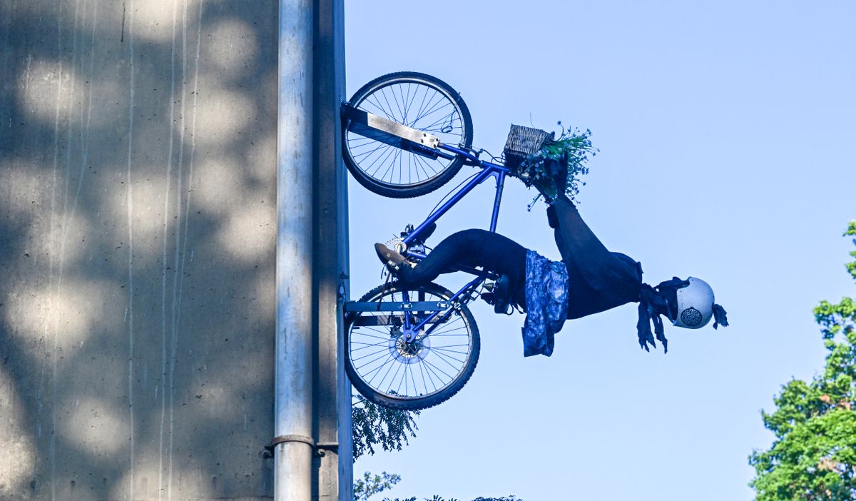 Mounted on a bridge support above the Peaceful Valley neighborhood is a sculpture of a bicyclist mounted to one of the Maple Street Bridge's supports Thursday, Aug. 8, 2024. The sculpture was placed without permission and was taken down, then later replaced and neighbors gathered to mark the occasion Thursday.  (Jesse Tinsley/THE SPOKESMAN-REVIEW)