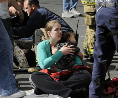 Rachel Popham give comfort 10-month-old infant who was involved in a one car accident near the corner of 32nd and Ray, April 1, 2010 in Spokane, Wa.  Popham said she heard the accident from one block away and came to assist the father and 3 children in the overturned car. (Dan Pelle)