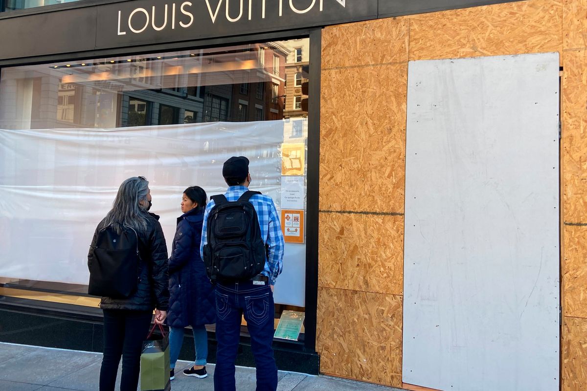 Union Square visitors look at damage to the Louis Vuitton store on Sunday, Nov. 21, 2021, after looters ransacked businesses late Saturday night in San Francisco.  (Danielle Echeverria)