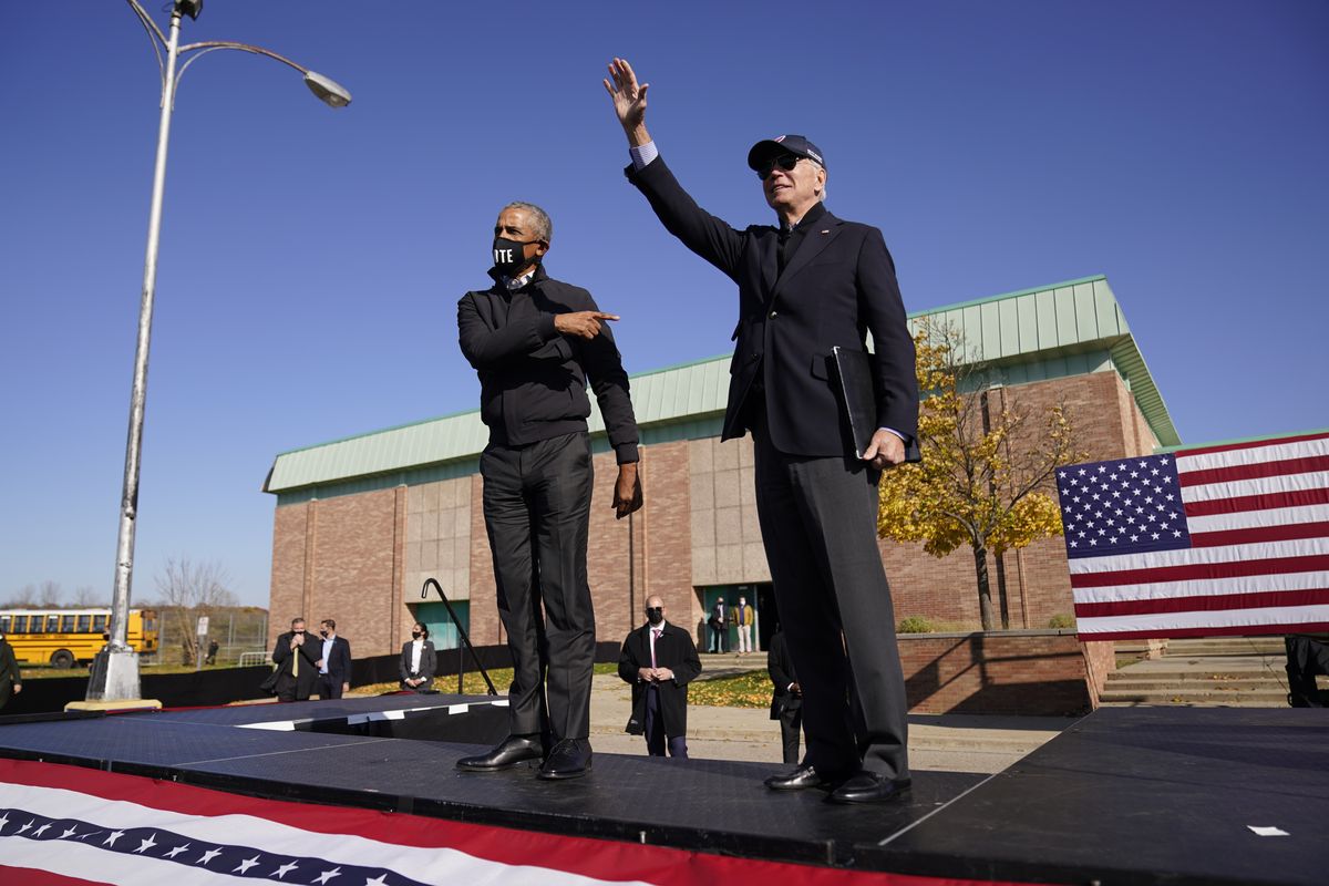Democratic presidential candidate former Vice President Joe Biden, right, and former President Barack Obama greet each other at a rally Saturday in Flint, Mich.  (Andrew Harnik)