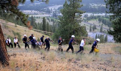 A rugged rescue: Spokane firefighters and ambulance crews snake their way along a trail below the bluff at High Drive and 29th Avenue after rescuing a man whose vehicle  went over the embankment about 6:35 p.m. Tuesday.  It took emergency crews about an hour to extricate the man, believed to be in his late teens,  from the vehicle.  The driver, who’d recently been released from a hospital, apparently had a medical emergency that caused him to black out,  police said. A hiker spotted the vehicle, which wasn’t visible from High Drive or Highway 195. The man’s condition was unknown late Tuesday. (Dan Pelle / The Spokesman-Review)