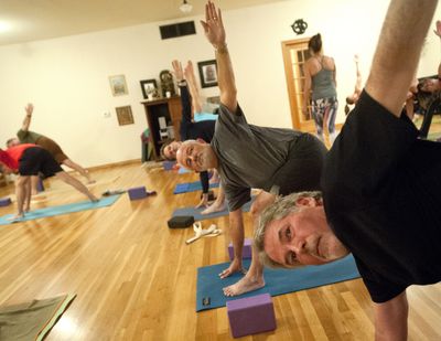 Pat Lacy, right, and Jim Millgard, center, practice yoga on Tuesday at Yoga Shala studio on the South Hill in Spokane. (Tyler Tjomsland)