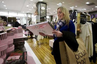 
Beckie Ambrose checks out a board game. While U.S. merchants are welcoming shoppers drawn by the cheaper dollar with expanded hours and other come-ons, the dollar's drop is also hurting their purchasing power, especially for those that import a lot of European goods.
 (The Spokesman-Review)