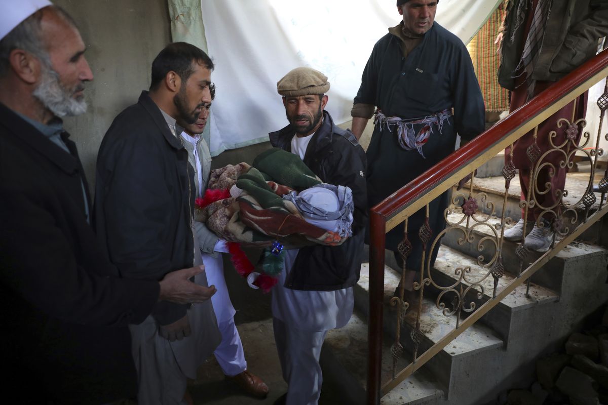 Relatives carry the dead body of a boy who was killed by a mortar shell attack in Kabul, Afghanistan, Saturday, Nov. 21, 2020. Mortar shells slammed into different parts of the Afghan capital on Saturday.  (Rahmat Gul)