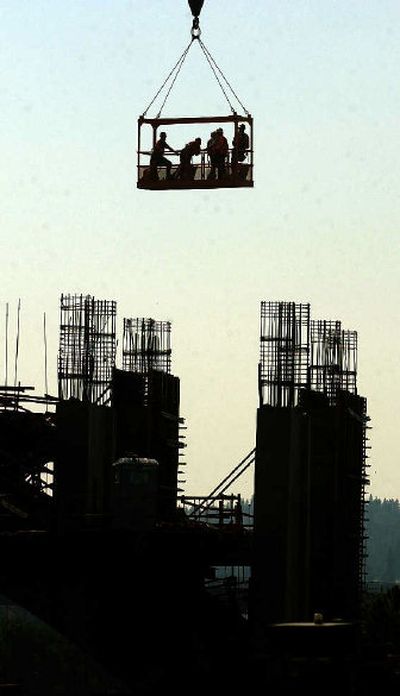 
A work crew waits as a crane-borne basket lowers them onto the skeletal Monroe Street Bridge archway in August of 2003. 
 (Jesse Tinsley / The Spokesman-Review)