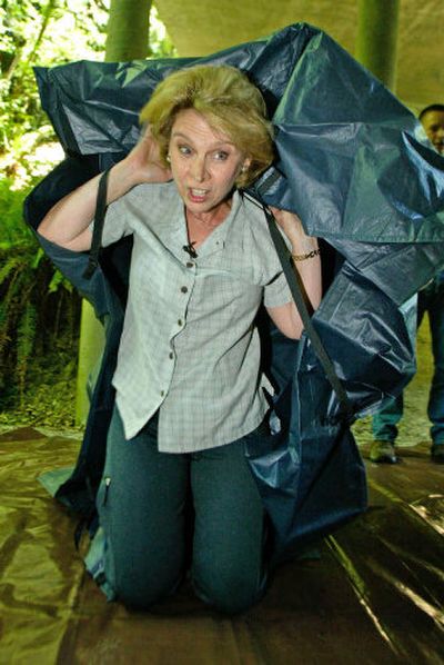 
Washington Gov. Christine Gregoire deploys a fire shelter Thursday in Chehalis, Wash. 
 (Associated Press / The Spokesman-Review)