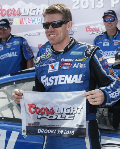 Carl Edwards holds the pole-sitter flag after qualifying for Sunday's NASCAR race at Michigan International Speedway. (Associated Press)