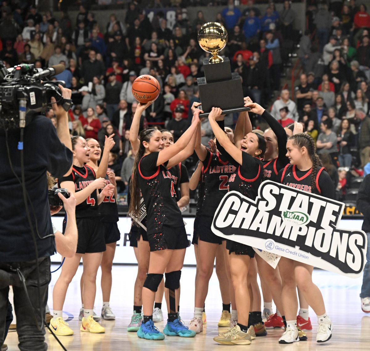 Neah Bay players raise their championship trophy Saturday after the Red Devils defeated Garfield-Palouse 46-36 in the State 1B tournament title game at the Arena. Neah Bay won its third consecutive state title. (Jesse Tinsley/THE SPOKESMAN-REVIEW)
