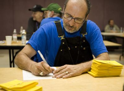 Boeing Machinists union member Jim Kakuschke  tallies the ballots Saturday after union members voted on a new contract offer.  (Associated Press / The Spokesman-Review)