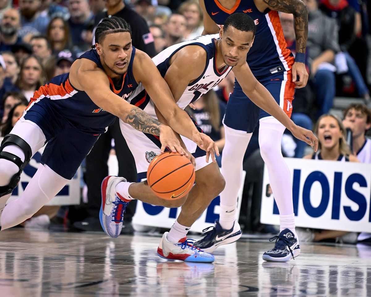 Pepperdine forward Jevon Porter (14) tries to strip the ball from Gonzaga guard Nolan Hickman (11) during the first half of a NCAA college basketball game, Thursday, Jan. 4, 2024, in the Spokane Veterans Arena.  (COLIN MULVANY)