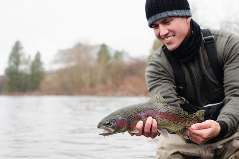 Fly fishing guide Sean Visintainer releases a native redband trout caught in the Spokane River. (Michael Visintainer / Photo by Michael Visintainer)