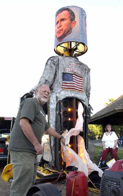 Ben Cohen, co-founder of Ben & Jerry's Ice Cream, shows a 12-foot-tall effigy of President Bush with fake flames shooting out his pants Tuesday in Riverfront Park.
(Associated Press / The Spokesman-Review)