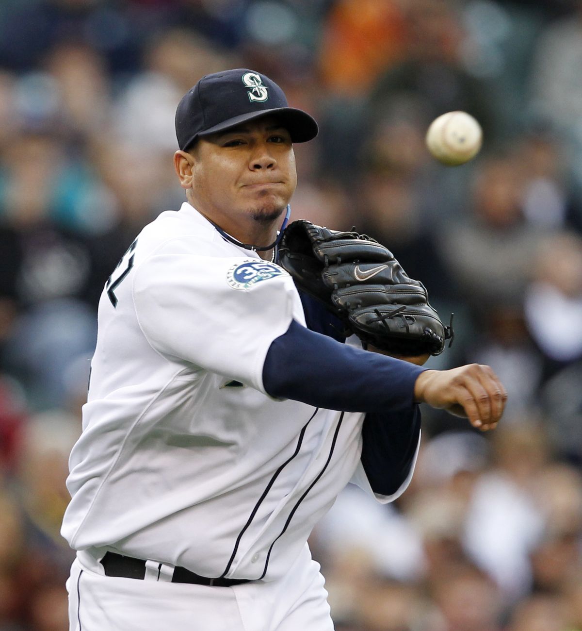 Seattle Mariners starting pitcher Felix Hernandez tosses to first on a sacrifice by Minnesota Twins