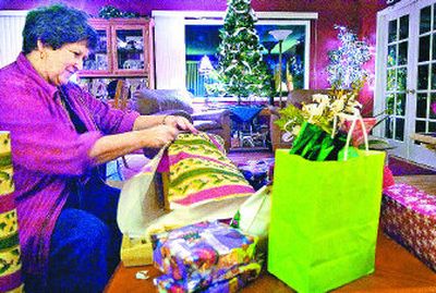 
Charlotte Karling wraps presents for her grandchildren in her home in Spokane on Tuesday afternoon.  
 (Holly Pickett / The Spokesman-Review)