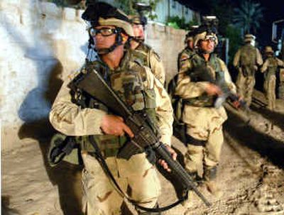 
U.S. soldiers raid a section of the city of Abu Ghraib, west of Baghdad, Iraq, while searching for weapons Saturday night.
 (Associated Press / The Spokesman-Review)