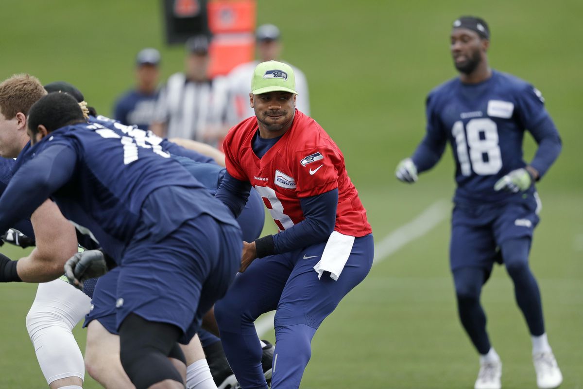 Seattle Seahawks quarterback Russell Wilson spins away from the line of scrimmage during practice Tuesday in Renton, Washington. (Elaine Thompson / AP)