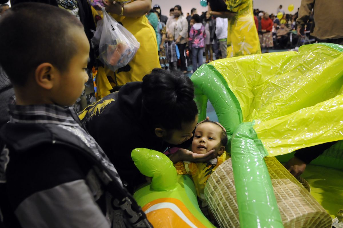 Marshallese line up to greet and toss money to 1-year-old Malachi Bertmen at the Southside Senior Center stage on Feb. 18 in Spokane. Hundreds gathered for the kemmem, a significant family event to celebrate the first birthday of a child. (Dan Pelle)