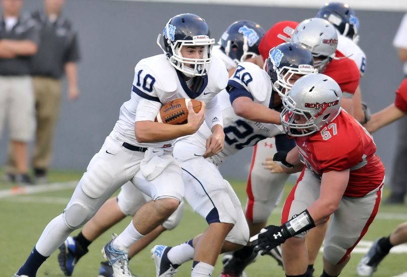 Gonzaga Prep Bullpups quarterback Zach Bonneau picks up yards as Ferris’ Adam Martin (57) tries to make the tackle. (Jesse Tinsley)