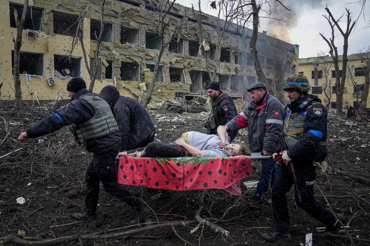 Ukrainian emergency employees and volunteers carry an injured pregnant woman from the damaged by shelling maternity hospital in Mariupol, Ukraine, Wednesday, March 9, 2022. A Russian attack has severely damaged a maternity hospital in the besieged port city of Mariupol, Ukrainian officials say.  (Evgeniy Maloletka)