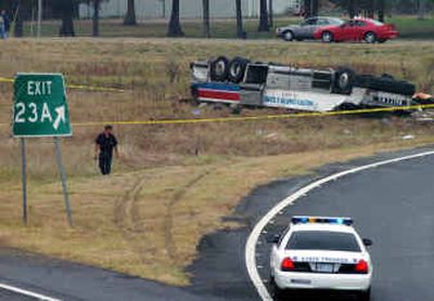 
An emergency worker looks over a set of tire tracks at the scene of a tour bus accident Saturday near Marion, Ark. 
 (Associated Press / The Spokesman-Review)