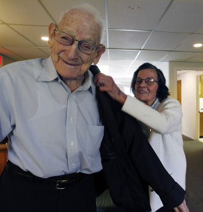 Marie Eberhardt helps her husband, George, 107, of Chester, N.J., after they got their annual flu shots last week. (Associated Press)