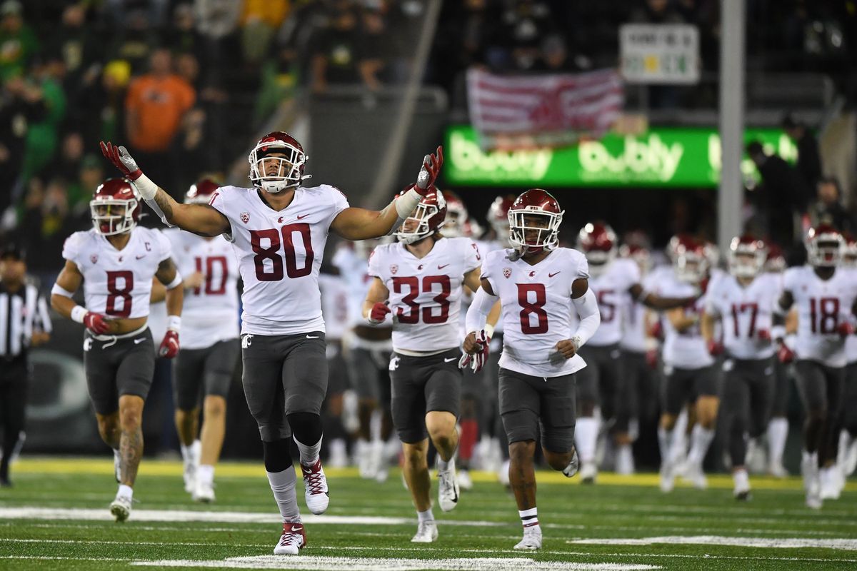 Washington State’s Brennan Jackson, front, cheers as he takes the field to face Oregon on Saturday in Eugene.  (Tyler Tjomsland/The Spokesman-Review)