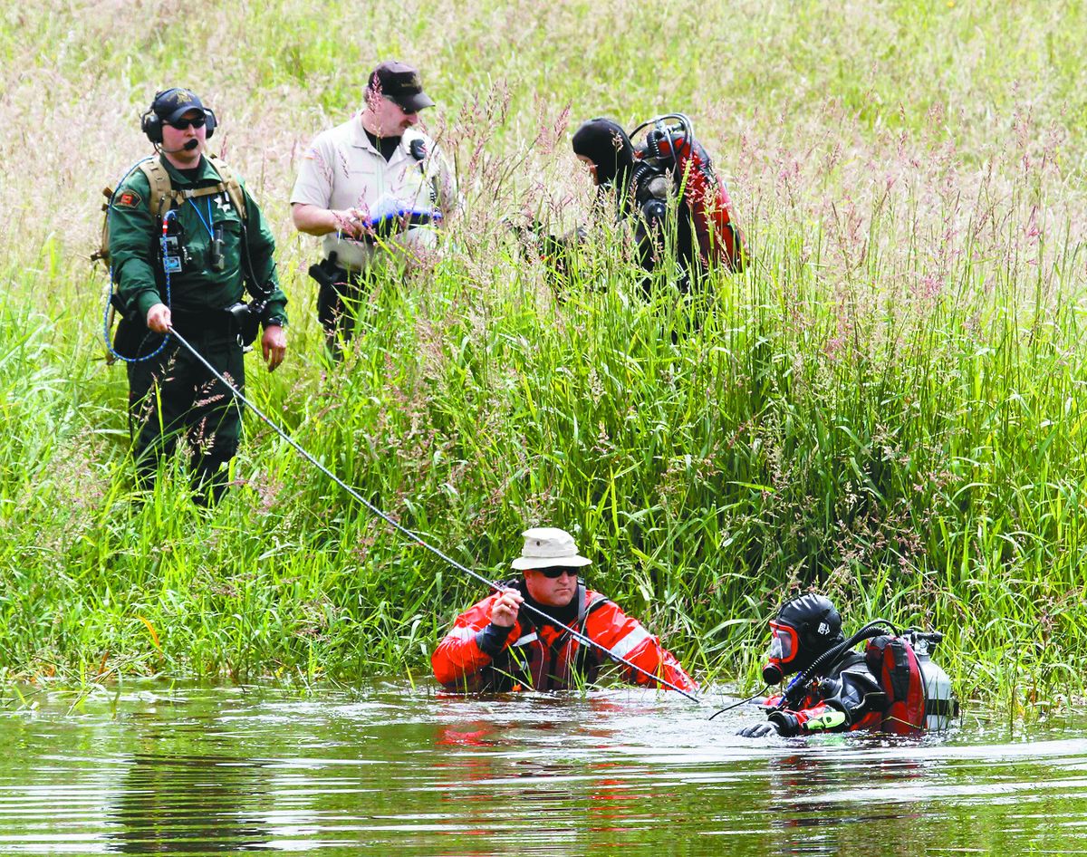A search and rescue team conducts the search of a small pond near Skyline Elementary School in Portland on Friday in  hopes of finding clues to the disappearance of 7-year-old Kyron Horman two weeks ago.  (Associated Press)