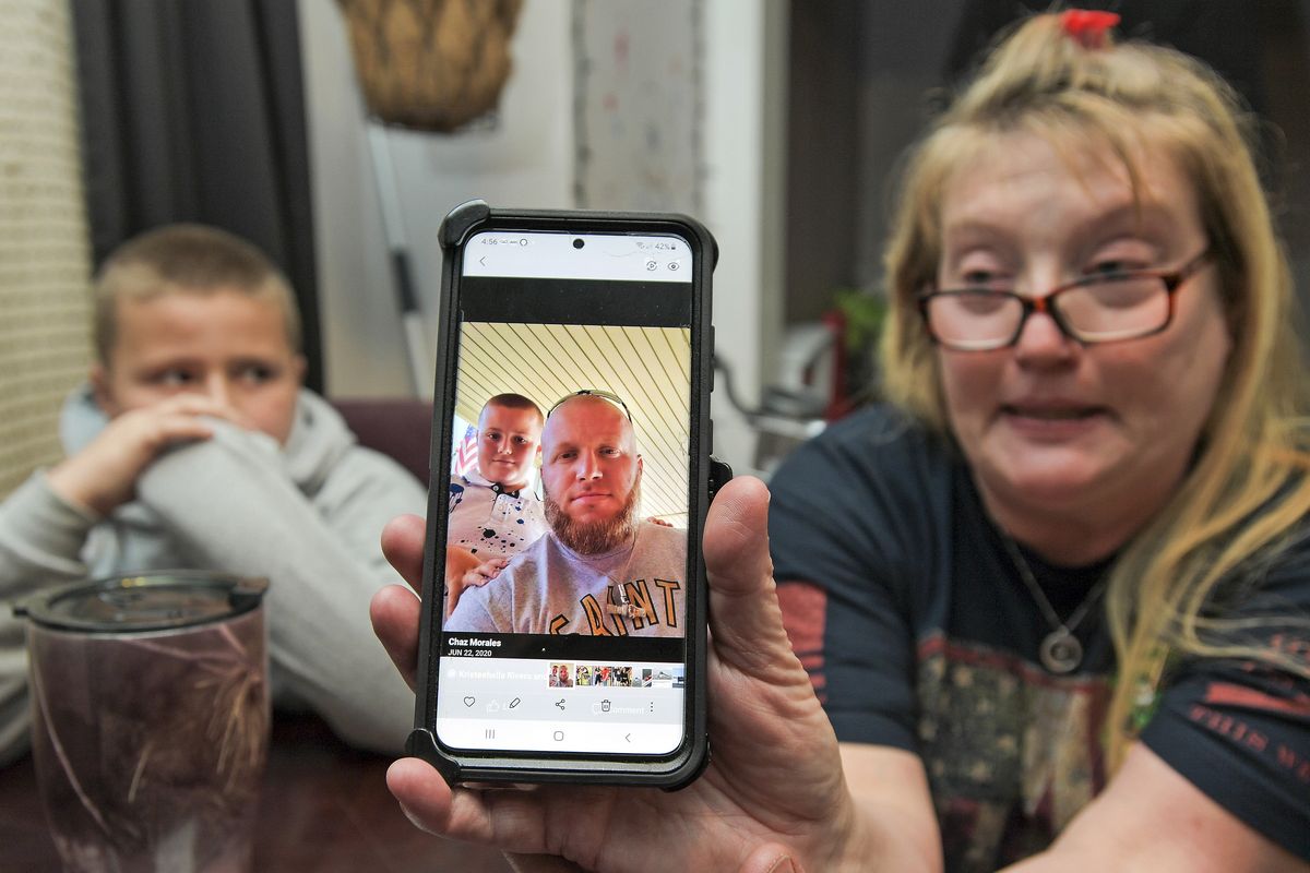Darra Ann Morales shows a photo of her son Chaz Morales, with Chaz Jr., 10, at left, at the family home in Slidell, La., Wednesday, April 14, 2021. Darra Ann Morales is the mother and Chaz Jr. is the son of Chaz Morales, who is one of the crew members missing from the capsized vessel Seacor Power that departed from Port Fourchon when severe weather struck Tuesday.  (Max Becherer)