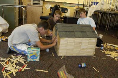 
From left, Kody Brown, Riley Nielson and Caden Hughes  use craft sticks as siding for the 