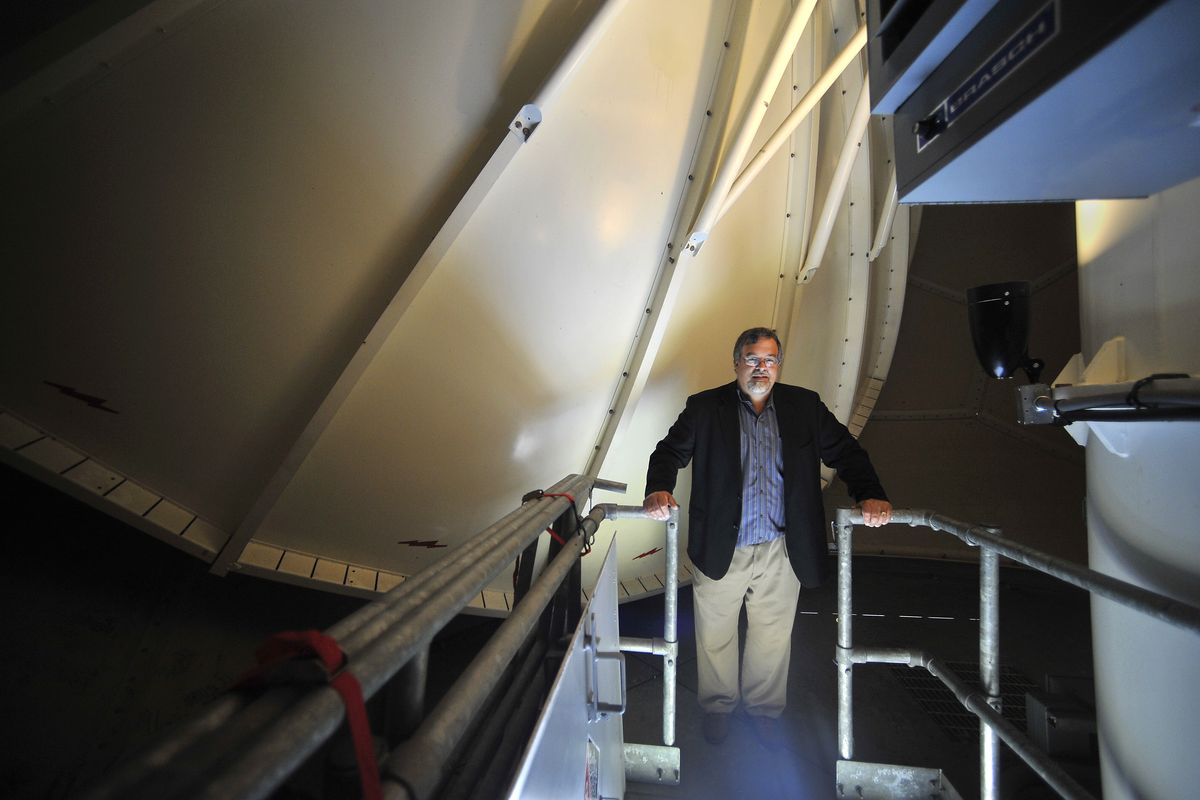 Livingston stands in front of the Doppler radar antenna in the tower. The radar upgrade will enable better estimation