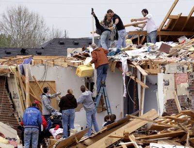 People clean up debris from a home in Murfreesboro, Tenn., on Saturday, the day after a deadly tornado ripped through the town.  (Associated Press / The Spokesman-Review)