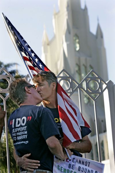 ORG XMIT: CASH102 Brian Costley, left, and his partner Jim Brady share a kiss, during a Kiss-in outside of the Church of Jesus Christ Latter Day Saints in San Diego on Wednesday, July 22, 2009. The Empowering Spirits Foundation held the Kiss-in to encourage dialogue between the Church of Latter Day Saints and the Gay and Lesbian community following the recent arrest of a gay couple who was caught while kissing on Main Street Plaza in Salt Lake City.  (AP Photo/Sandy Huffaker) (Sandy Huffaker / The Spokesman-Review)