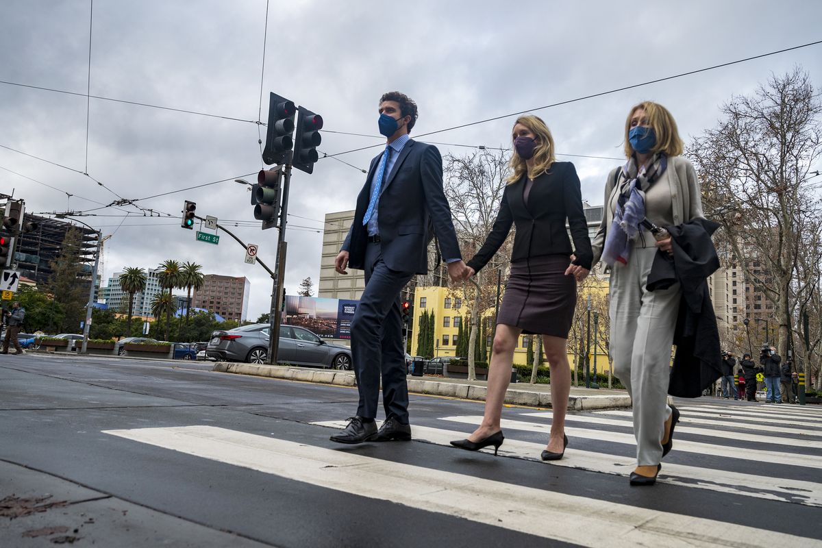 Former Theranos CEO Elizabeth Holmes, center, with her partner, Billy Evans, left, and mother, Noel Holmes, right, leaves federal court in San Jose, Calif., Thursday, Dec. 23, 2021. The jury began their third day of deliberations in her fraud and conspiracy trial on Thursday.  (Nic Coury)