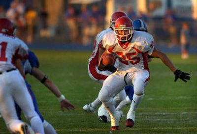 
Sandpoint senior running back Kurt Stoll surveys the field while breaking through a hole against Coeur d'Alene. He carried the ball 35 times for 183 yards. 
 (Jed Conklin / The Spokesman-Review)