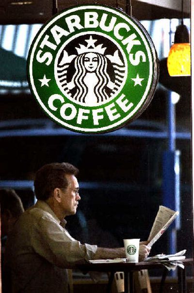 
A man reads a newspaper with his morning cup of coffee at a Starbucks in downtown Portland, Ore. 
 (Associated Press / The Spokesman-Review)