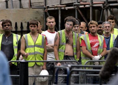 
Construction workers pause for two minutes of silence in central London's Tavistock Square on Friday, where the No. 30 bus was bombed one year ago in terrorist attacks.
 (Associated Press / The Spokesman-Review)
