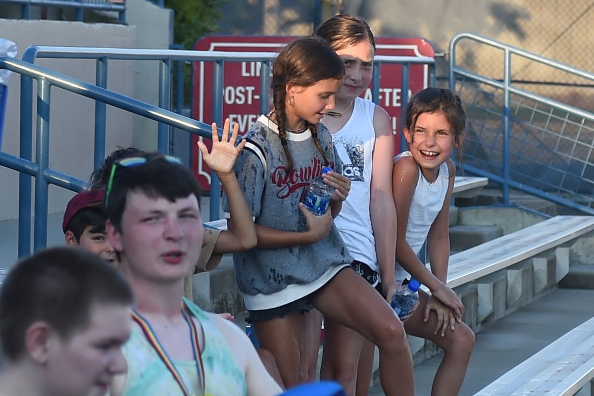 A group of kids watch as the left field bleachers get sprayed with water in the top of the third inning during a Spokane Indians baseball game Tuesday, June 29, 2021 at Avista Stadium in Spokane WA. Gametime temperature was a record 109 degrees. (James Snook/For The Spokesman-Review)