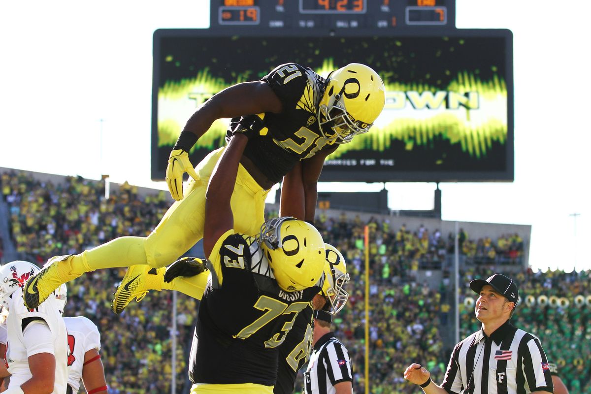 Oregon offensive lineman Tyrell Crosby gives a lift to running back Royce Freeman Oregon after a second-quarter touchdown Saturday. (Associated Press)