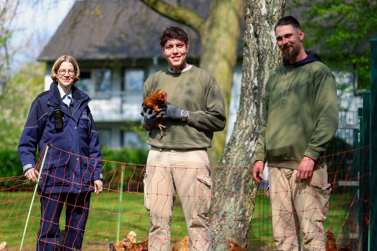 Officer Anika Schäfer, left, with Ryan and Manuel, is responsible for the prison’s chicken project. The inmates take care of young chickens that would otherwise end up at the slaughterhouse.  (German Press Agency)