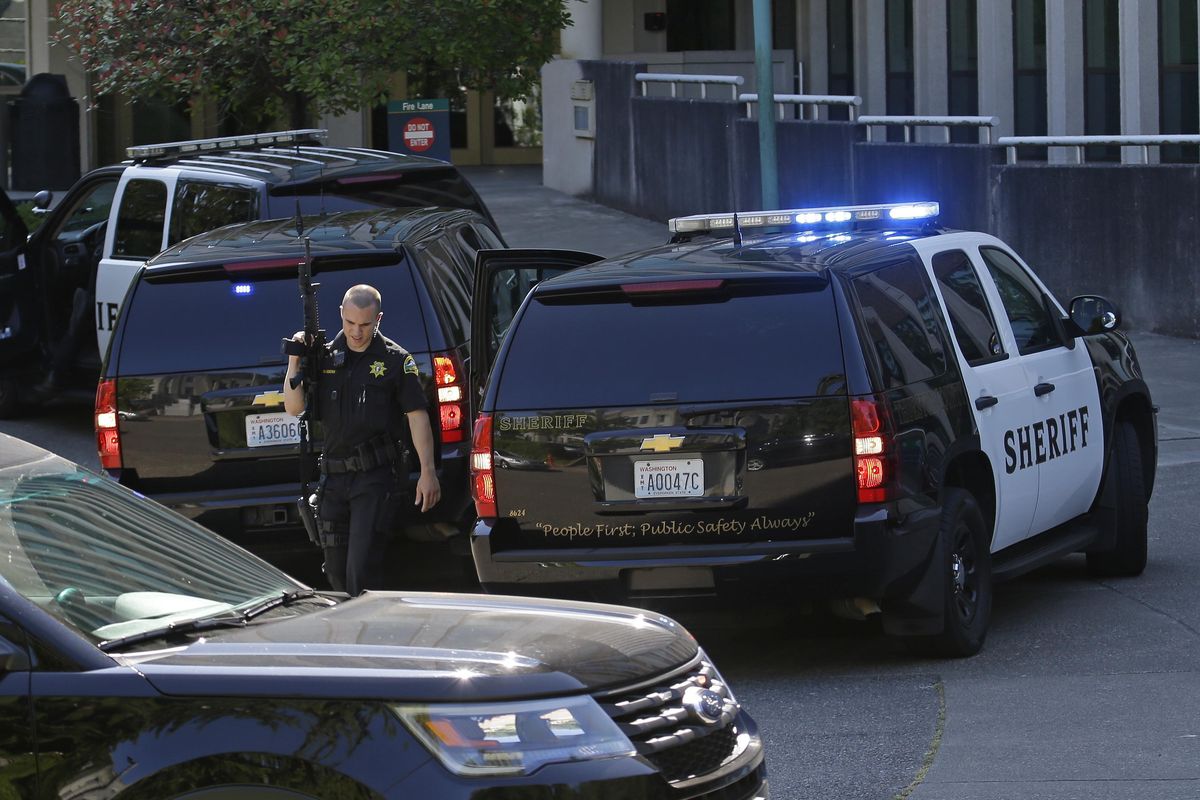 A Thurston County sheriff’s deputy walks with a gun after a lockdown at the state Capitol campus in Olympia. was lifted Wednesday, July 12, 2017. The Washington State Patrol said in an email alert that troopers conducted a thorough search of buildings on campus Wednesday after reports of suspicious noises, but that nothing was found. (Ted S. Warren / Associated Press)