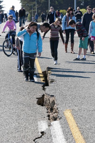 People inspect the cracked South Brighton Bridge approach after an earthquake in Christchurch, New Zealand, today.  (Associated Press)