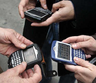 
Three people use their BlackBerry devices in New York's Times Square. 
 (Associated Press / The Spokesman-Review)