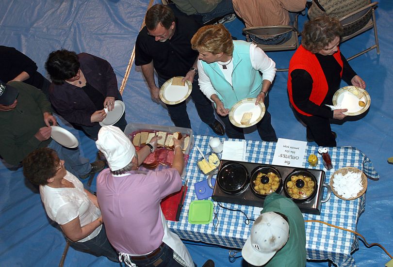 People line up for bread and bite-sized pronto pups Saturday, March 27, 2010, at the fourth Annual Men Who Cook For Women Who Wine event in the Hingham Community Center in Hingham, Mont. (Nikki Carlson / Havre Daily News)