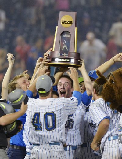 Closing pitcher David Berg hoists the trophy as UCLA celebrates its first NCAA baseball title after 8-0 win over Mississippi State.