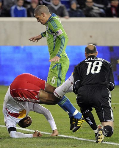 Sounders goalkeeper Kasey Keller grabs the ball as Red Bulls' Thierry Henry, left, tumbles over. (Associated Press)