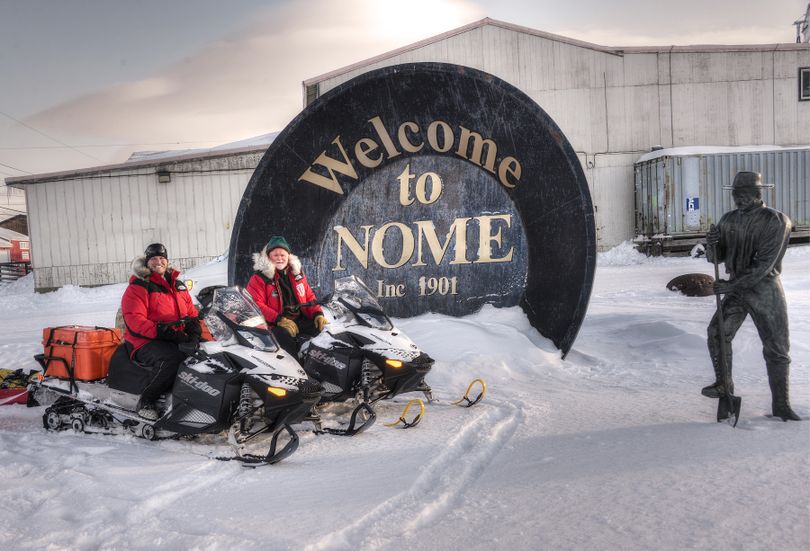 Josh Rindal of Spokane and Bob Jones pose with their snowmobiles  at the world's biggest gold pan in Nome. Rindal and Bob Jones of Kettle Falls were snowmobiling 1,400-miles along the route of Alaska's famous Iditarod Sled Dog Race in March 2014. (Robert Jones)