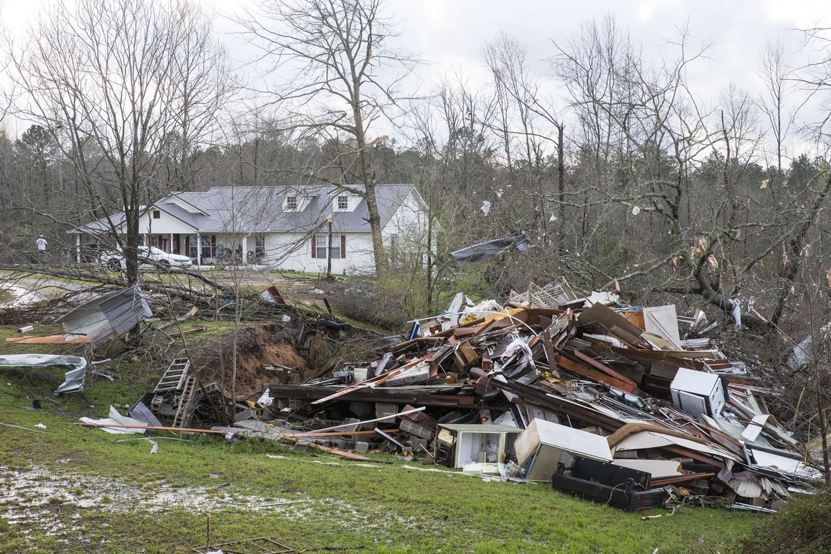 Debris litters weather-damaged properties Thursday at the intersection of County Road 24 and 37 in Clanton, Ala., the morning following a large outbreak of severe storms across the southeast.  (Vasha Hunt)
